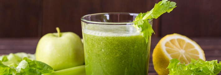 Das Bild zeigt Lebensmittel, die häufig bei Diäten eine Rolle spielen: Staudensellerie, Zitrone, Salat und ein grüner Smoothie