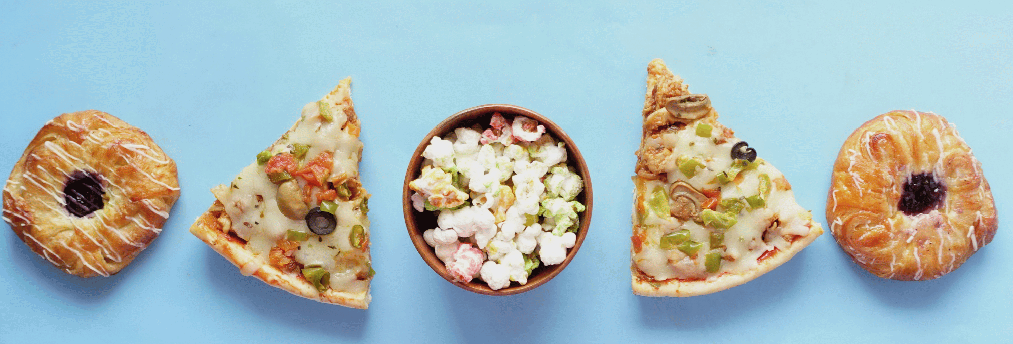 Das Bild zwig auf hellblauem Hintergrund Bagels, Pizzastücke und einen Salat mit Schafskäse